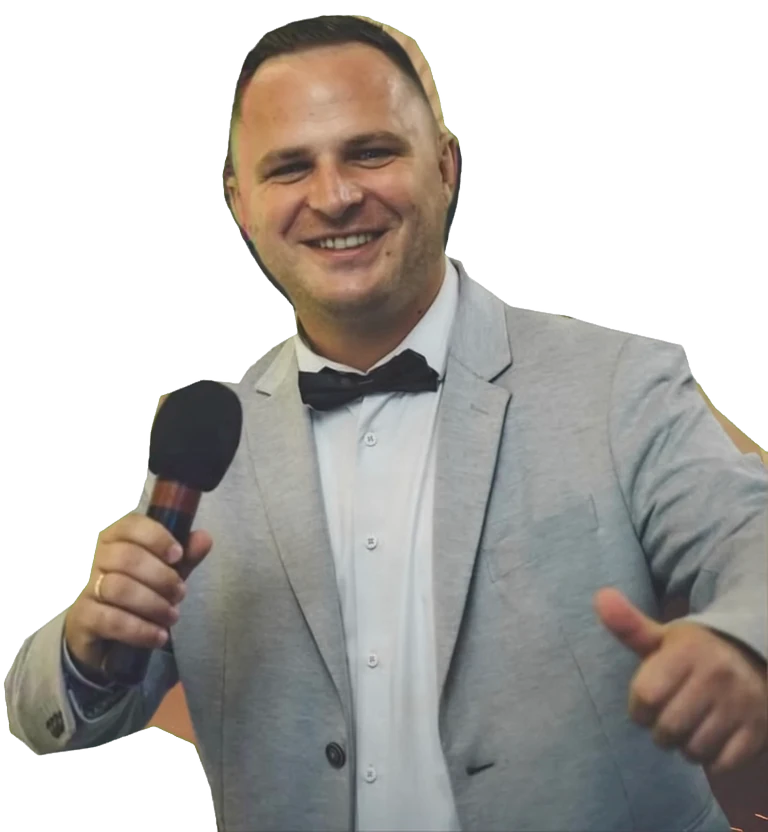 Jámbor Dénes vőfély és ceremóniamester, mikrofonnal a kezében, hüvelykujját felmutatva